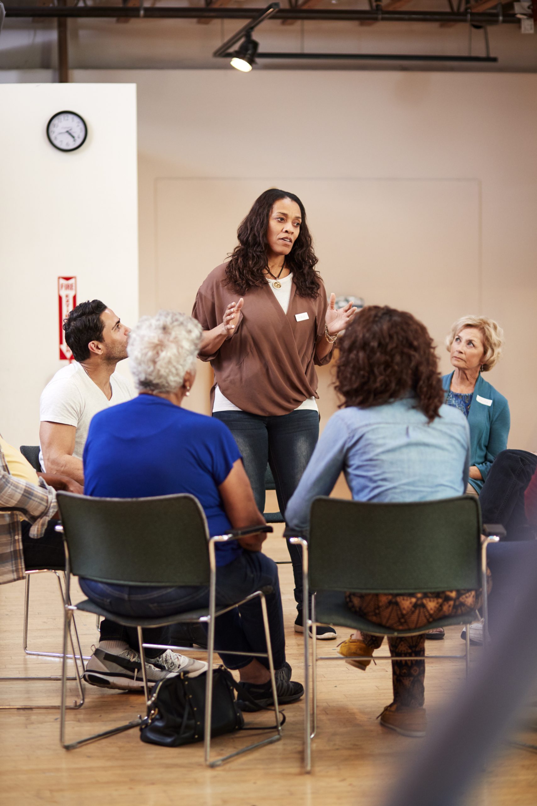 Woman Standing To Address Self Help Therapy Group Meeting In Community Center Women in detention stories
